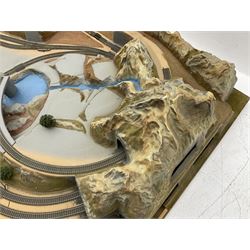 '00' gauge - table-top moulded plastic model railway layout with various rocky outcrops, tunnels, waterfall to lake, loops of Fleischmann track supplemented by Hornby track, bridges, kit built buildings and other accessories; together with Bachmann Class 150 2-car DMU Set and Hornby Northern Rail Class 142 2-car Set; both boxed; and small quantity of other rolling stock, three controllers etc  200 x 120cm