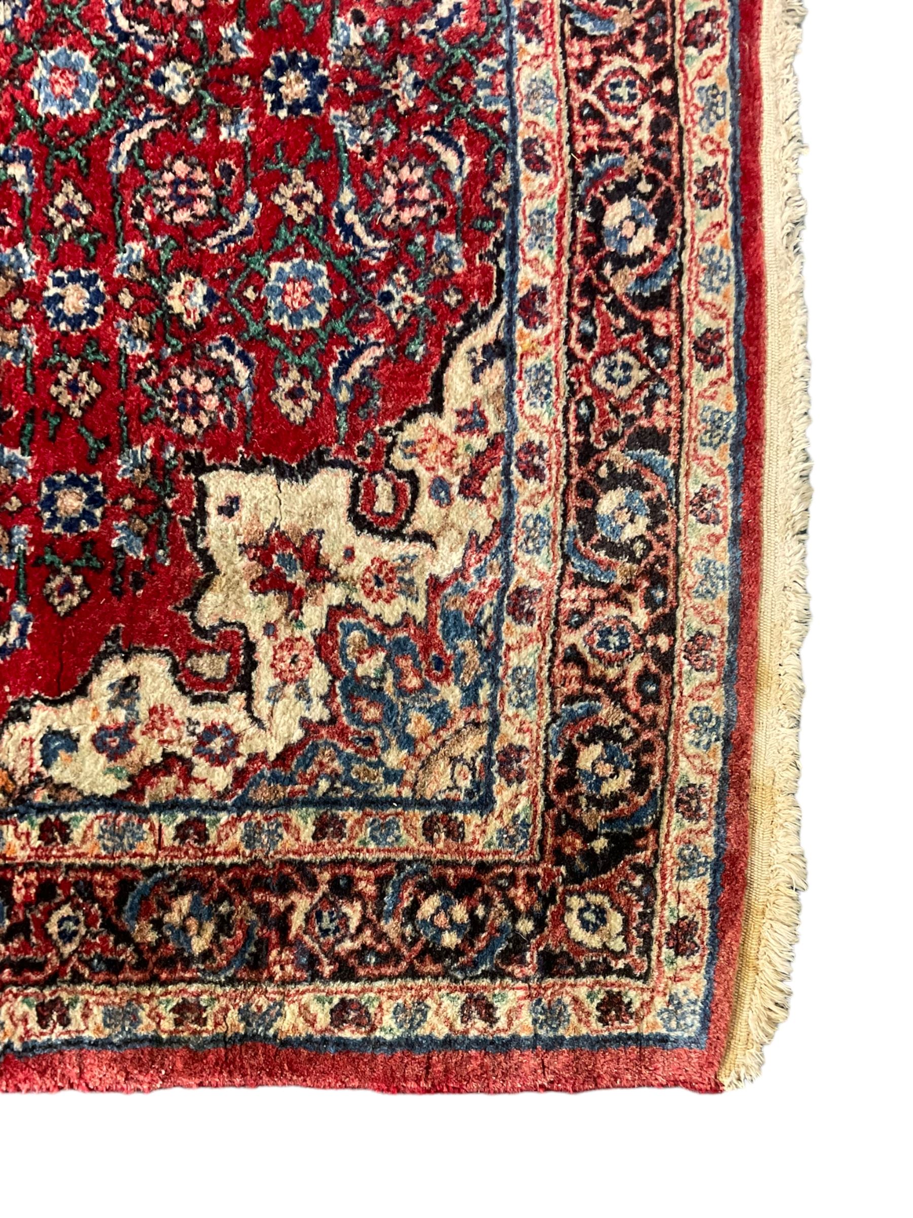 Persian design crimson ground rug, the field decorated with central