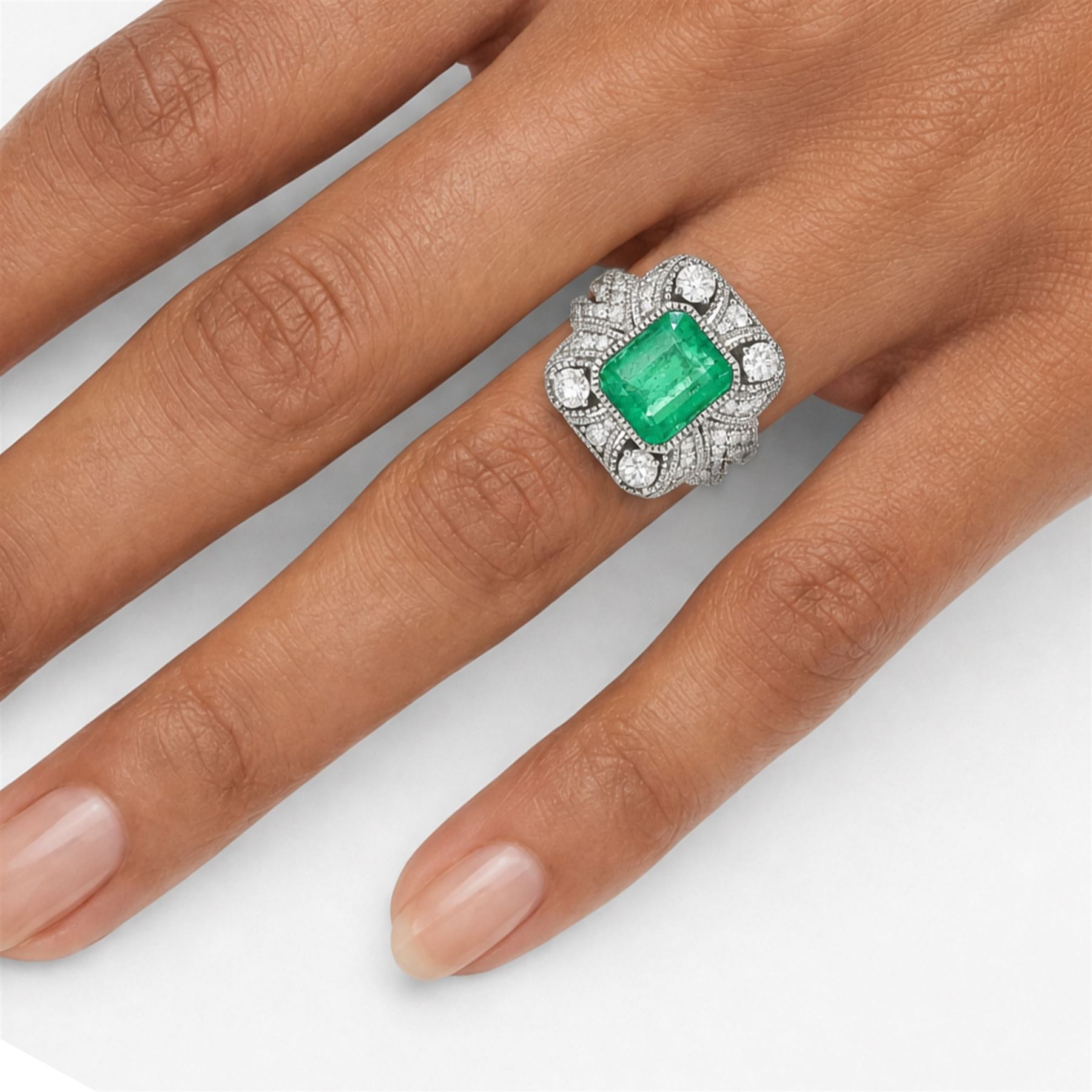 Platinum emerald and diamond cluster ring, single octagonal cut emerald of 2.52 carat, surrounded by milgrain set round brilliant cut and single cut diamonds, stamped PT950, total diamond weight 0.82 carat