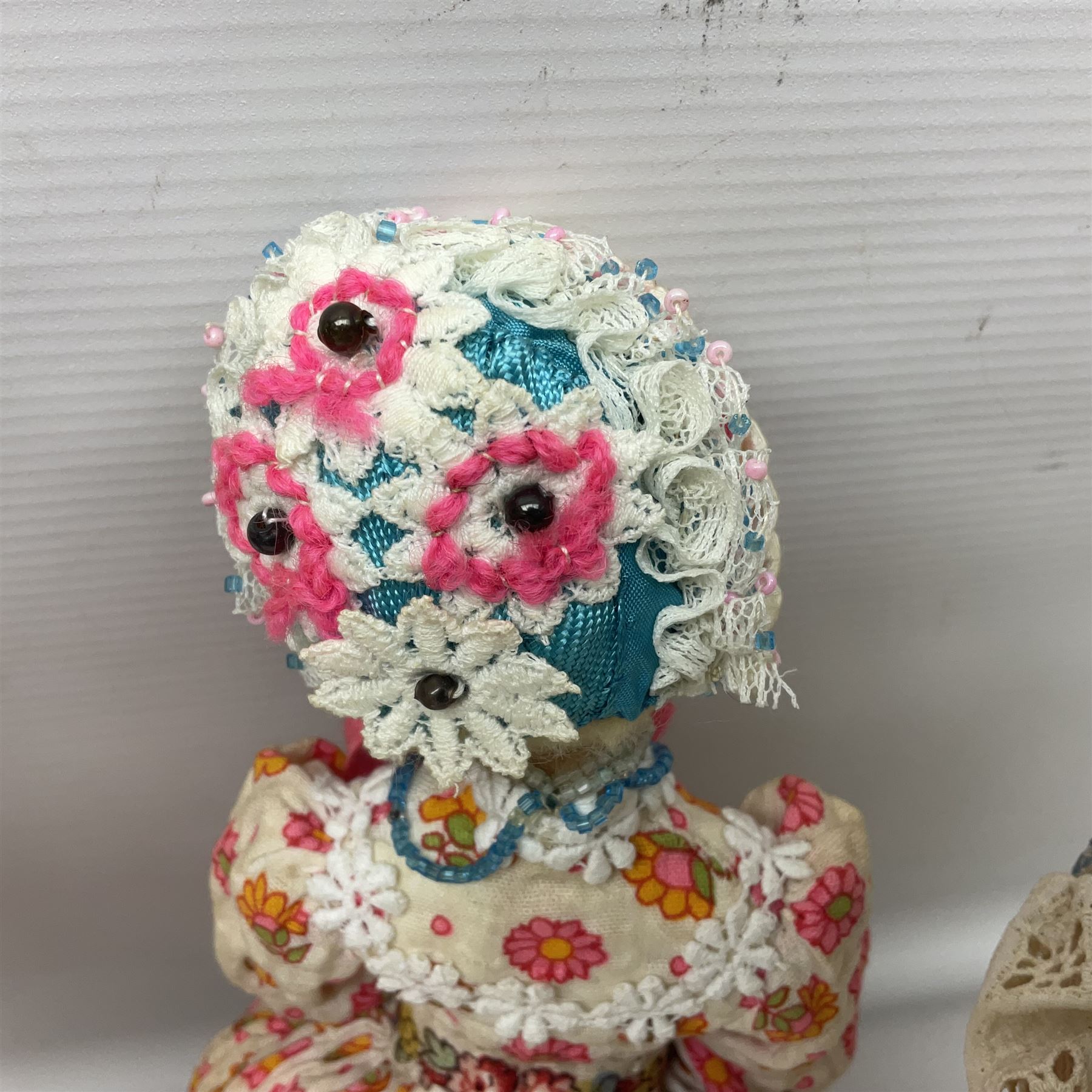 Anna Meszaros Hungary - three hand made needlewrok figurines - each wearing a lon floral dress and bonnet and holding a bouquet of flowers, tallest H32cm (3)  Auctioneer's Note: Anna Meszaros came to England from her native Hungary in 1959 to marry an English businessman she met while demonstrating her art at the 1958 Brussels Exhibition. Shortly before she left for England she was awarded the title of Folk Artist Master by the Hungarian Government. Anna was a gifted painter of mainly portraits and sculptress before starting to make her figurines which are completely hand made and unique, each with a character and expression of its own. The hands, feet and face are sculptured by layering the material and pulling the features into place with needle and thread. She died in Hull in 1998.