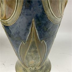 Early 20th century Royal Doulton stoneware vase, decorated with a stylized floral design below a wavy rim, monogrammed B.N, possibly for Bessie Newbery, H28cm, together with an early 20th century glazed jug, heavily carved throughout (2)