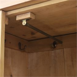 Traditional waxed pine single wardrobe, featuring single panelled door above base drawer, loop handles