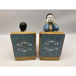 Pair of 20th century Chinese figural bookends, modelled as children in traditional blue dress sat reading and kneeling upon stacks of books, H22cm