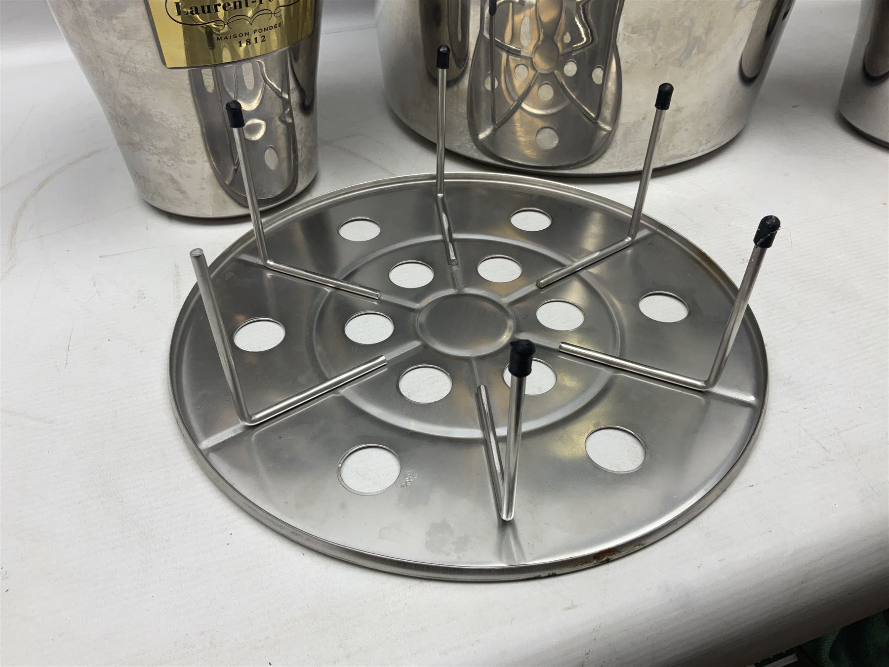 Stainless steel Laurent-Perrier champagne bucket, with engraved brass plaque and grip to swing handle, together with three matching smaller, largest D38cm (4)