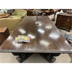 Large 19th century carved oak library table, the rectangular top with lunette carved edge over cartouche panelled and carved  scroll frieze, the central tapering rectangular support relief carved with masks and garlands, on four carved seated lion supports at each corner, on flat angular stretcher with recessed castors stamped ‘Bartholomew & Fletcher, London’