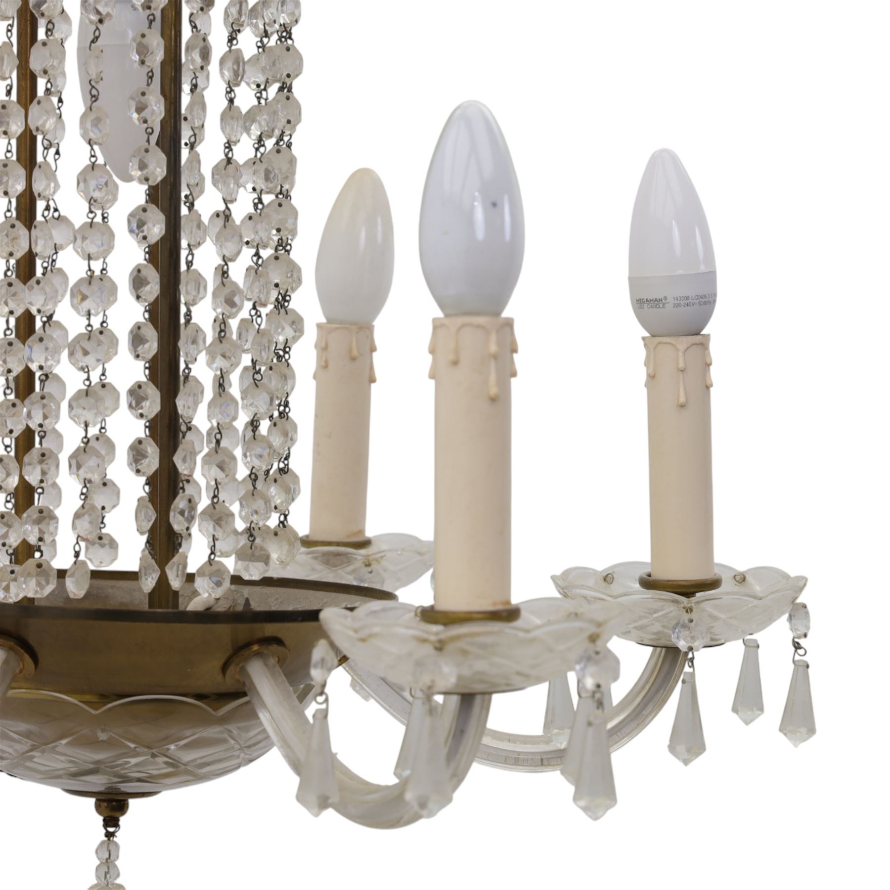 Early 20th century Continental glass and brass six branch chandelier, the central baluster column hung with graduated faceted glass drops, issuing six scrolling glass arms each fitted with candle sconces and drip pans, suspended from a fluted glass canopy