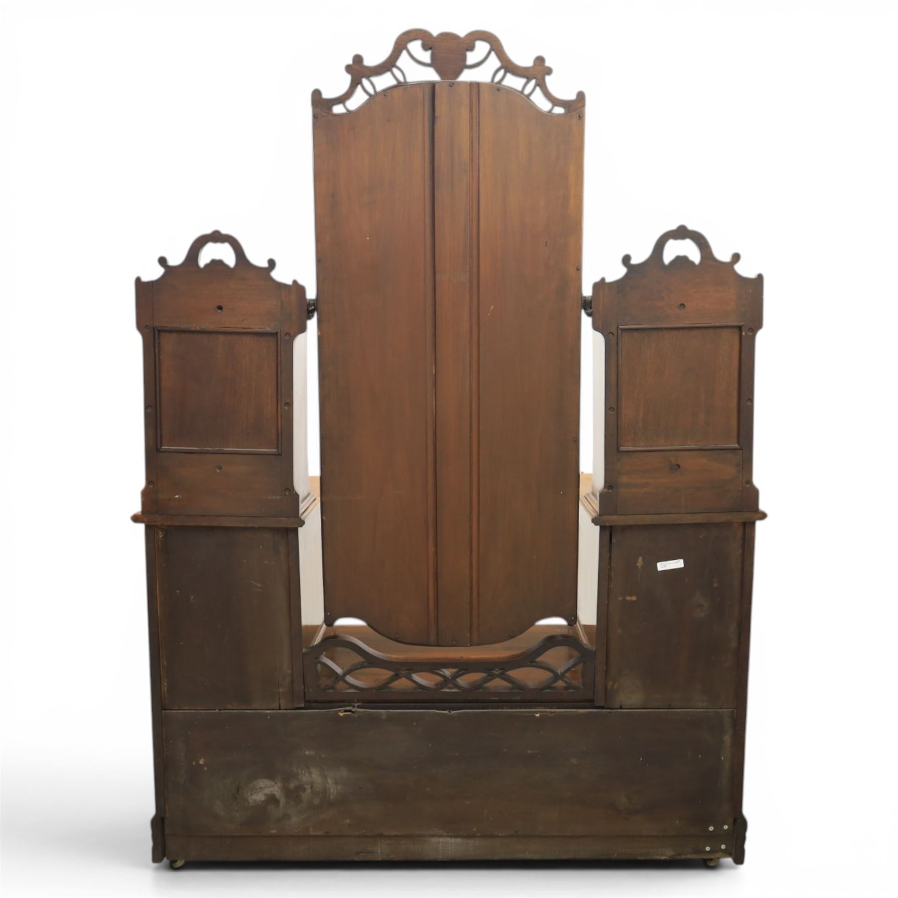 Edwardian figured walnut dressing chest, with central tilting mirror with pierced fret work, flanked by cabinet with figured walnut panelled door above a trinket drawer, with four short over a long long drawer, raised on a plinth base with castors 