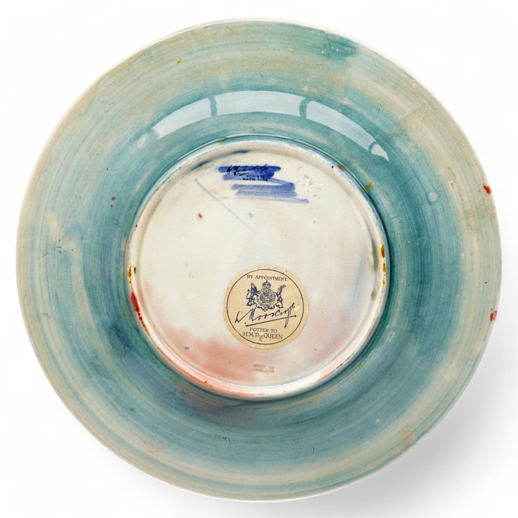 William Moorcroft plate decorated with the leaves and berries pattern, with signature mark and 'Potter to H.M. the Queen' to base, with stand, D29cm