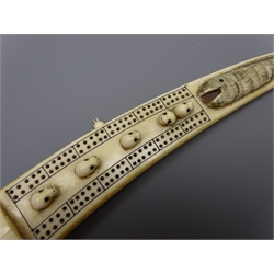  Scrimshaw Walrus tusk Cribbage board, decorated with seals heads and whale in relief, reverse with walrus and hunters in boats, L31cm   