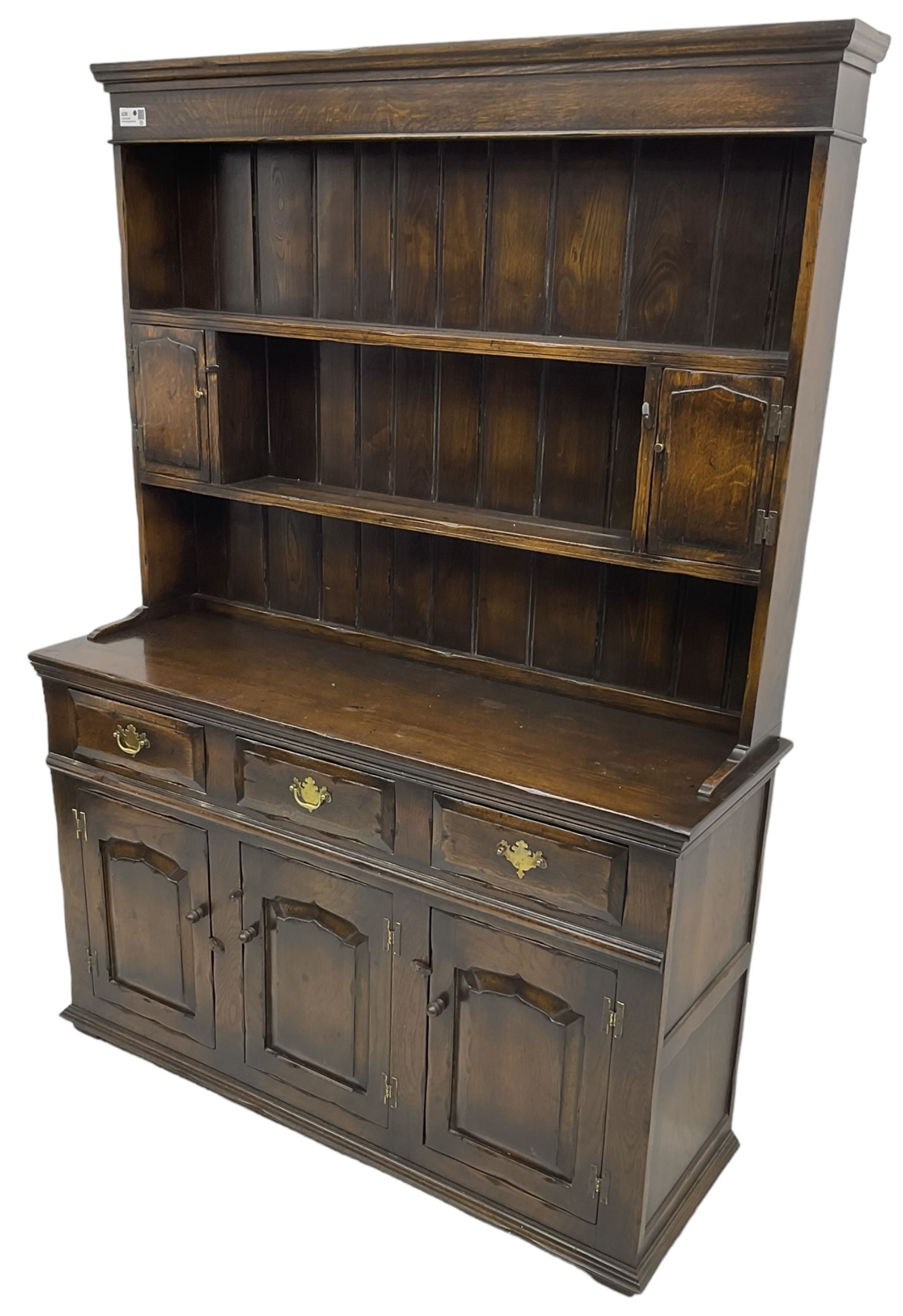 Georgian design oak dresser, the two-tier plate rack with two flanking spice cupboards, the base fitted with three drawers over three arched fielded panelled cupboards, lower moulded edge on block feet