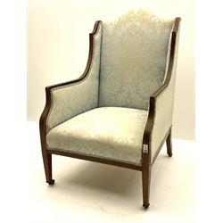 Edwardian walnut framed and inlaid armchair, upholstered in a pale and floral patterned fabric, raised on square tapered supports and brass castors 