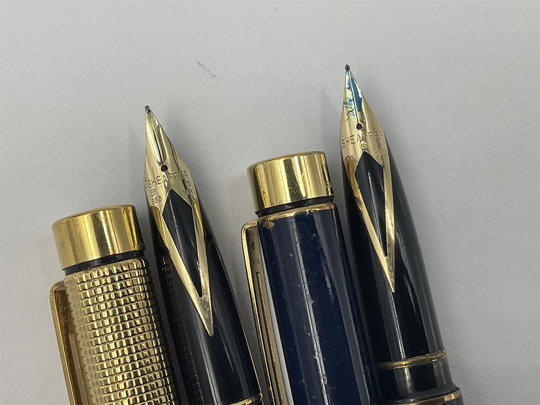 Sheaffer Targa 1011 Diamond Square fountain pen, the gold plated barrel with nib stamped 14K 585, together with another Sheaffer Targa fountain pen with blue barrel and gold nib stamped 14K 585 and matching ballpoint, and Sheaffer ballpoint pen with sterling silver barrel, largest L13.5cm (4)
