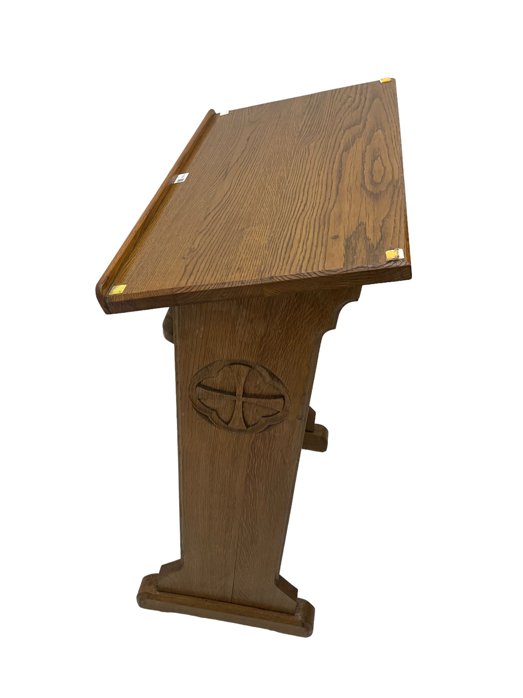 20th century ecclesiastical oak lectern, the sloped rest on moulded end supports with carved decoration, the front panelled with Gothic style carved and pierced tracery, on sledge feet