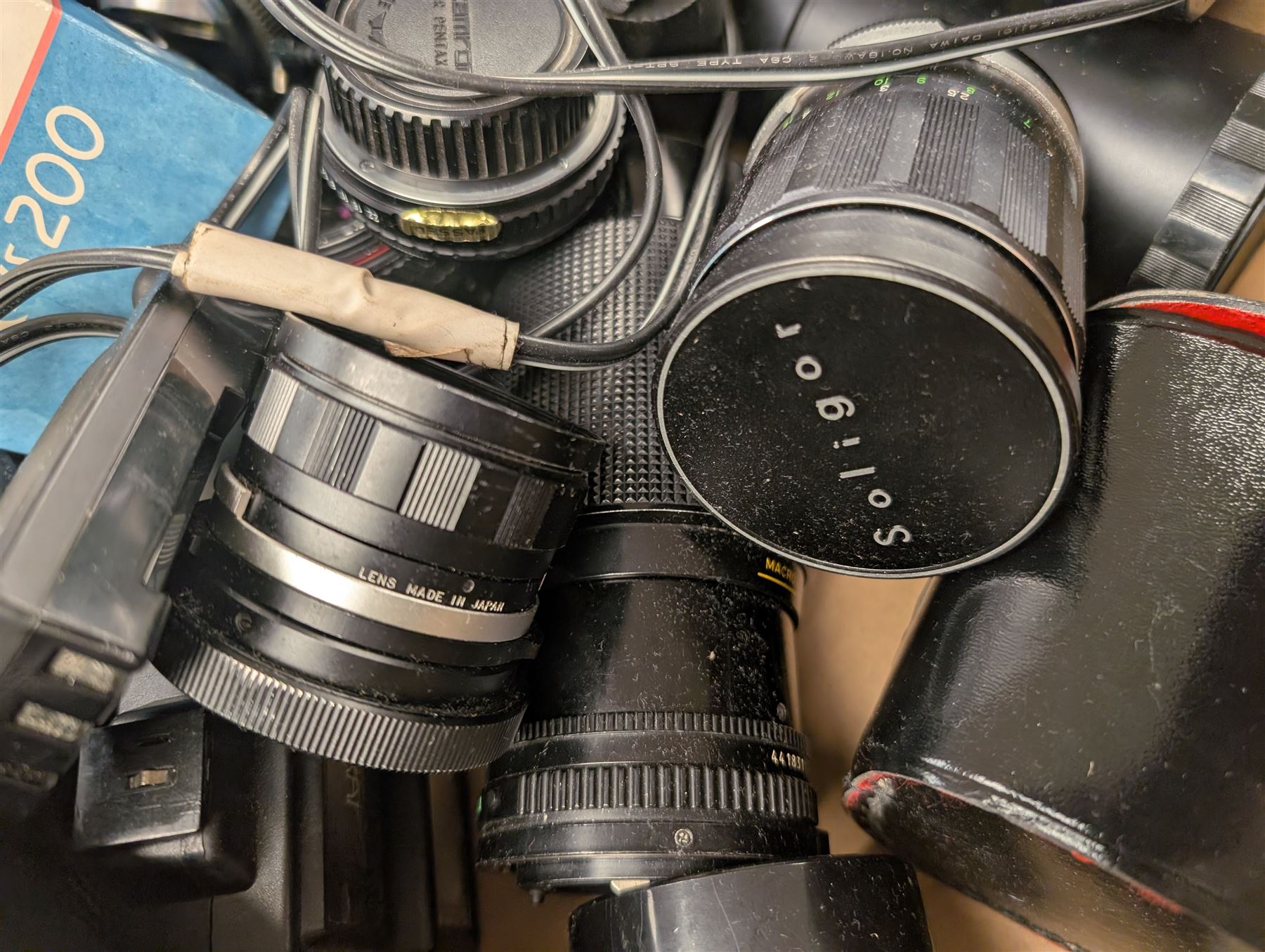 Collection of camera lenses, including Tamron, Praktica, Minolta and Soligor examples