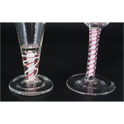 18th century drinking glass, the funnel bowl upon a double series opaque colour twist stem with red and white outer spiral threads around a central tightly twisted column, and circular foot, H13cm, together with another similar 18th century example with trumpet bowl, H11cm