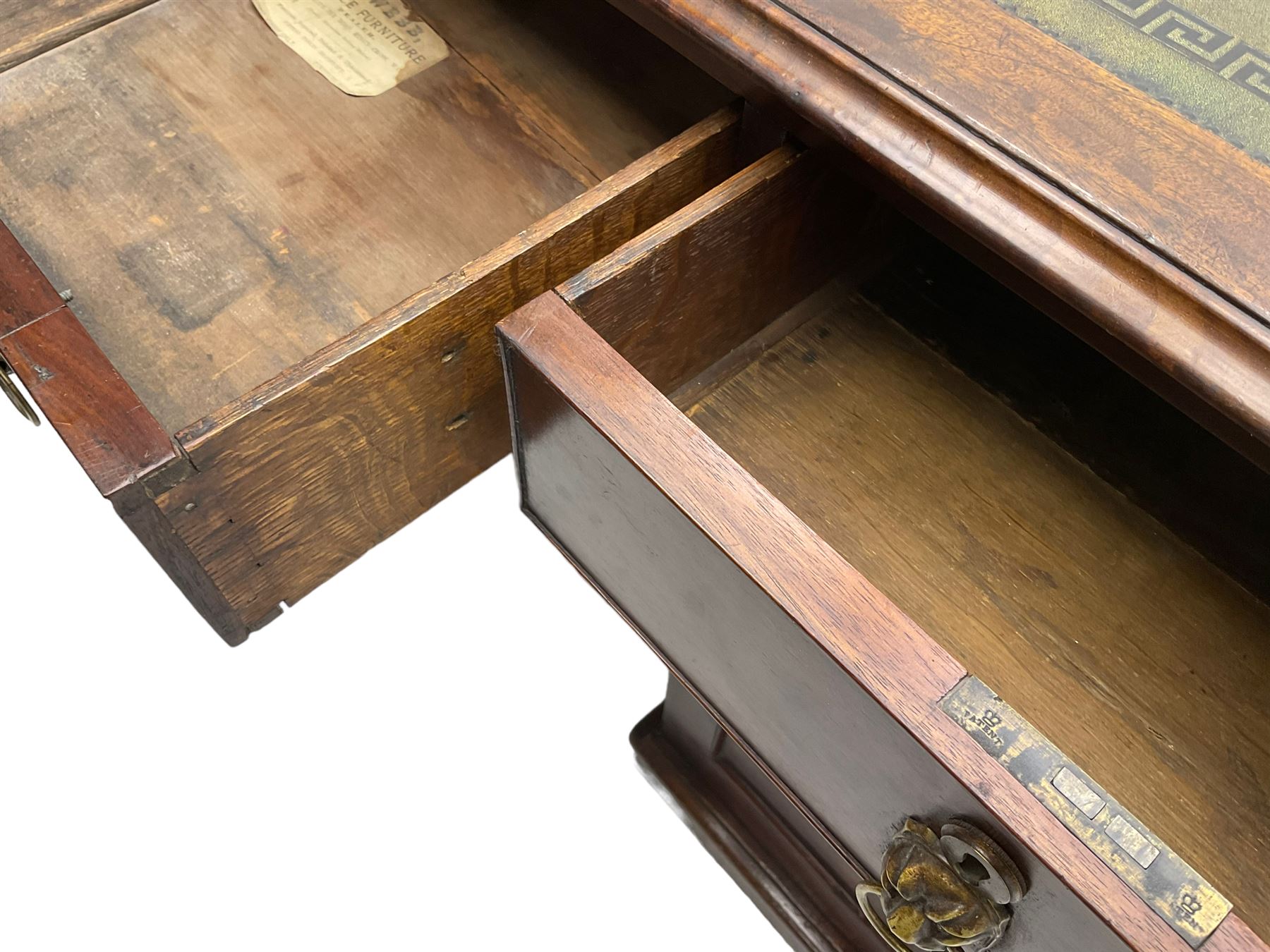 George III mahogany twin pedestal partners desk, rectangular top with moulded edge and an inset green tooled leather writing surface with Greek key design border, fitted with three cock-beaded frieze drawers to each side, each pedestal with three graduating drawers with an opposing panelled cupboard enclosing a single shelf, the facias fitted with brass lion mask plates with ring handles, the lower moulded edge over a plinth base and castors, London furniture dealers label to interior of drawer inscribed 'J. Webb, Office Furniture 323, Gray's Inn Road, King's Cross'  H75cm  W153cm  D97cm