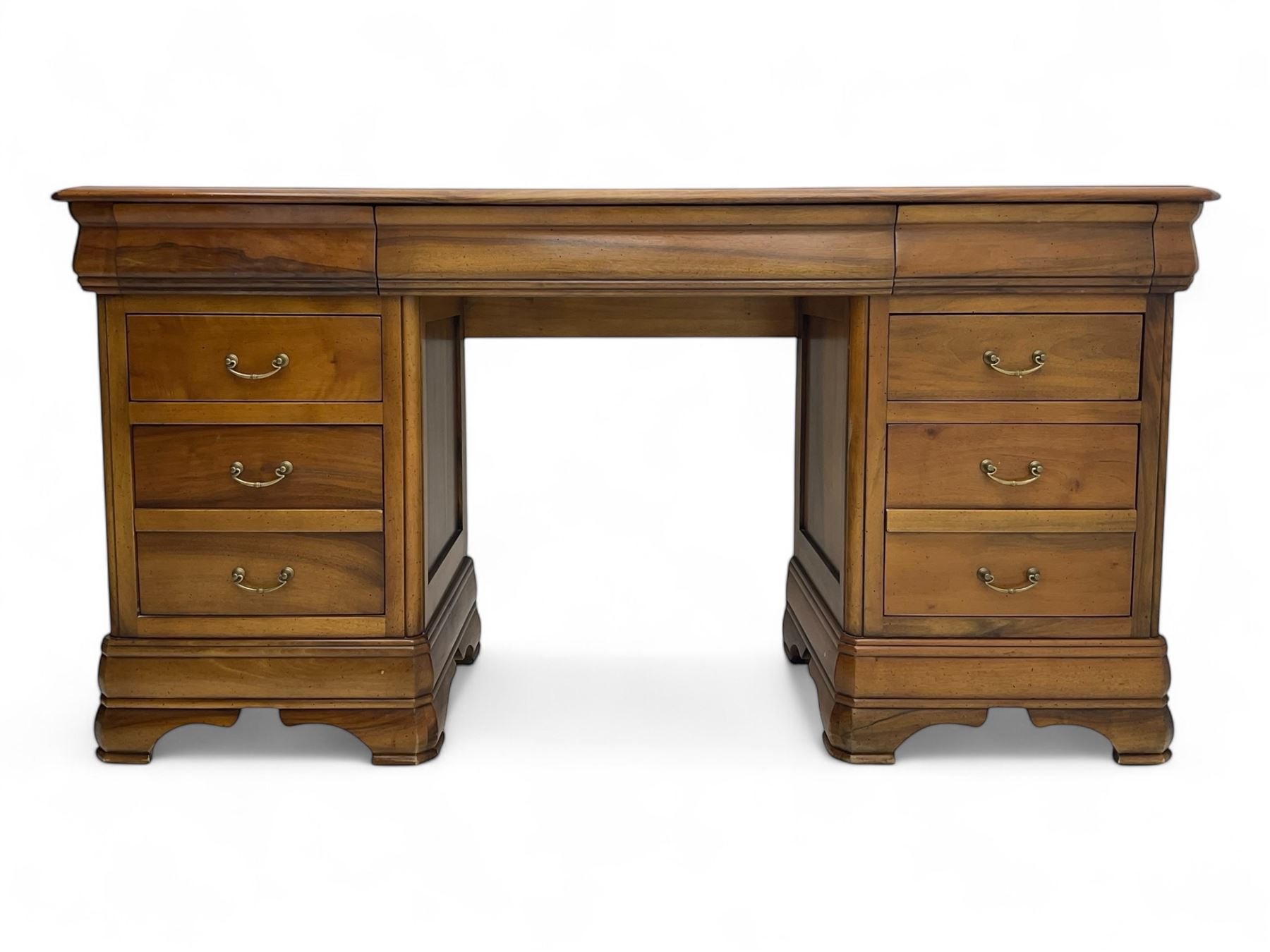 French cherry wood kneehole desk or dressing table, moulded rectangular top over twin pedestal bases each housing three drawers with brass-effect swing handles, resting on bracket feet