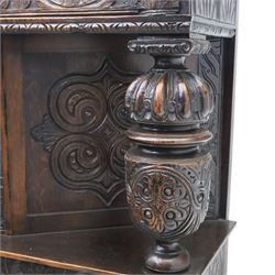 Jacobean revival oak side cabinet, rectangular top above carved frieze of stylised foliage and lunettes, fitted with a central cupboard doors with applied carved panels, above a frieze drawer, supported on turned and carved vase-shaped supports, united by stretcher tier and lower shelf