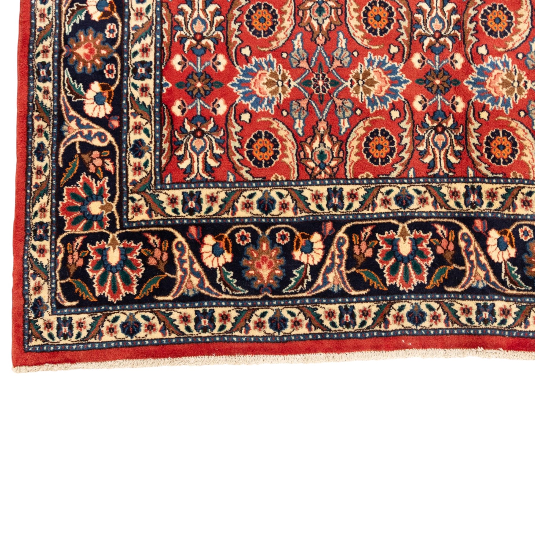North West Persian carpet, the red field decorated with an all over repeating design of palmettes, rosettes and curling serrated leaves in indigo, ivory and ochre tones, enclosed by an indigo scrolling floral border and ivory flowerhead guard bands