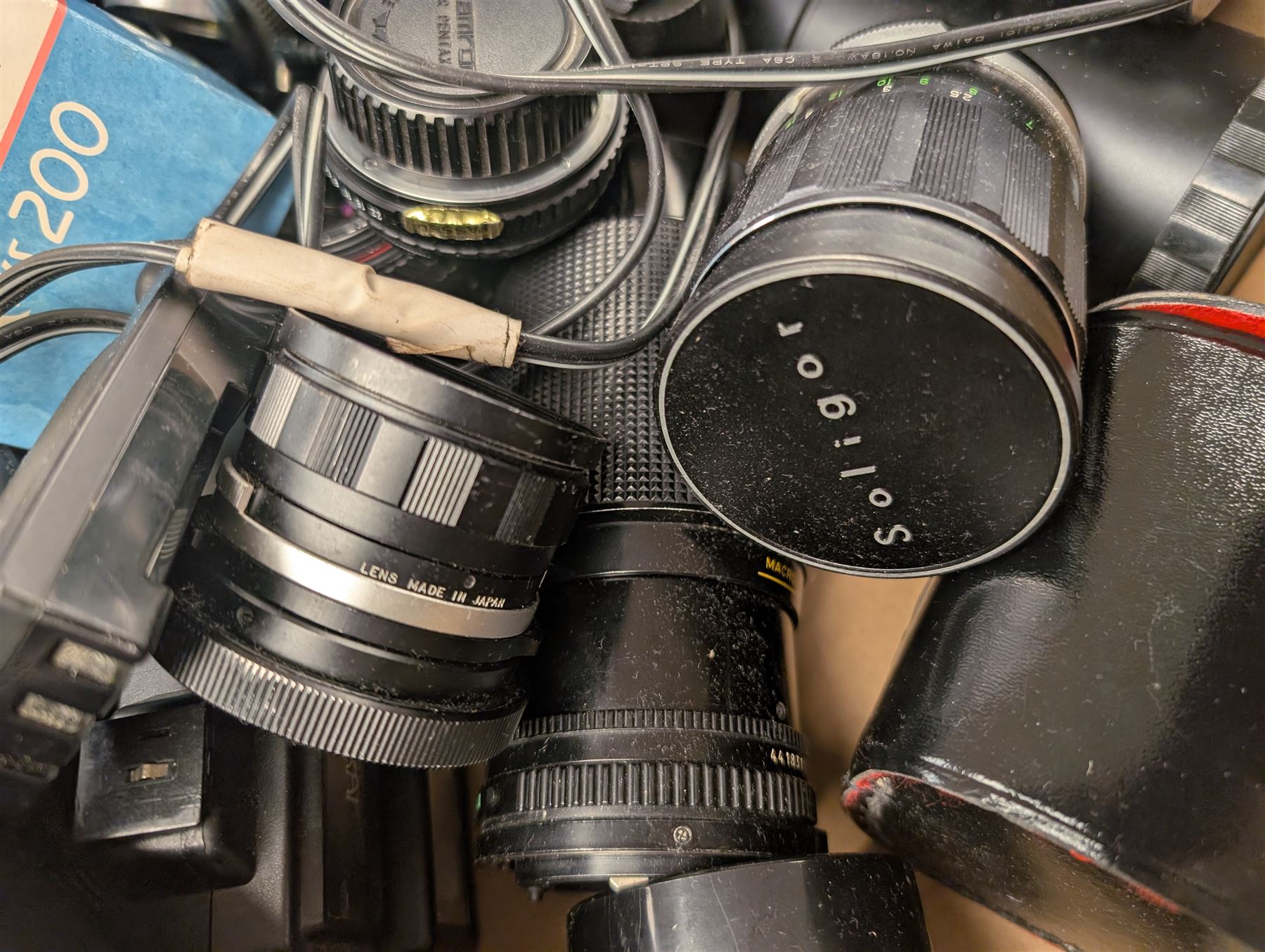 Collection of camera lenses, including Tamron, Praktica, Minolta and Soligor examples