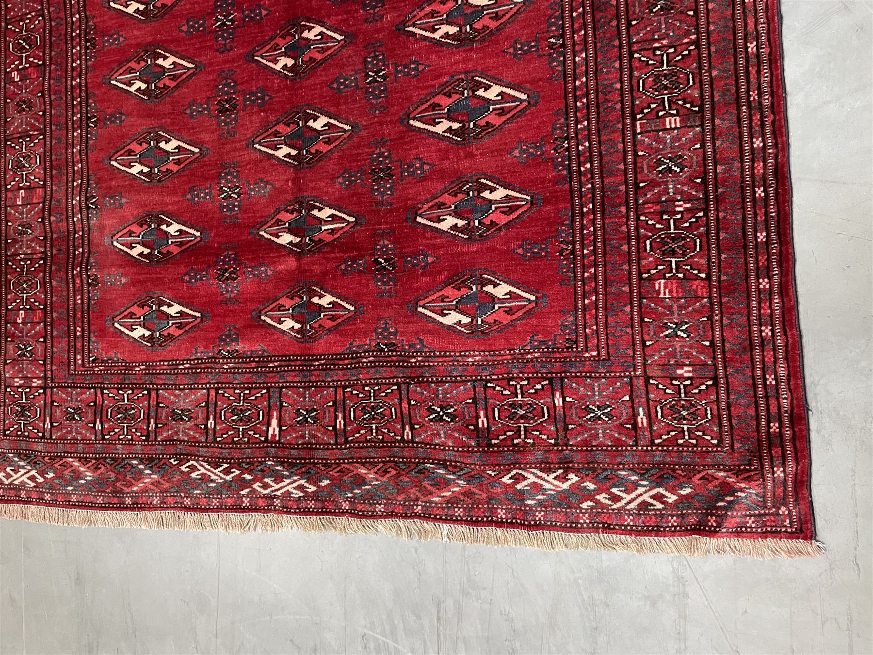 Turkman Bokhara rug, red ground field decorated with repeating Gul motifs