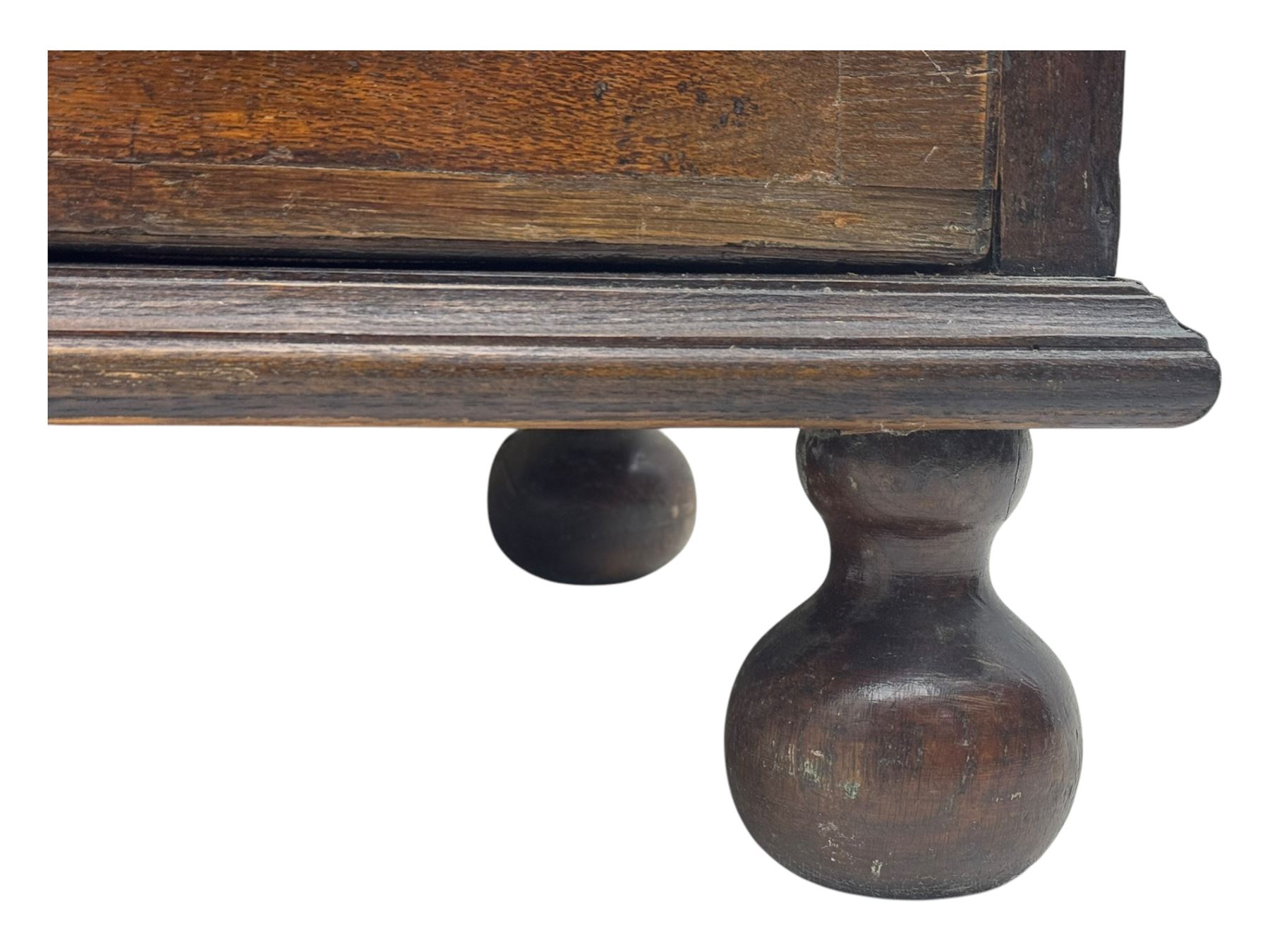 George III oak bureau, sloped fall-front enclosing a fitted interior with pigeonholes, small drawers, and a central compartment, over two short and two long drawers, brass escutcheons and drop handles, raised on bun feet