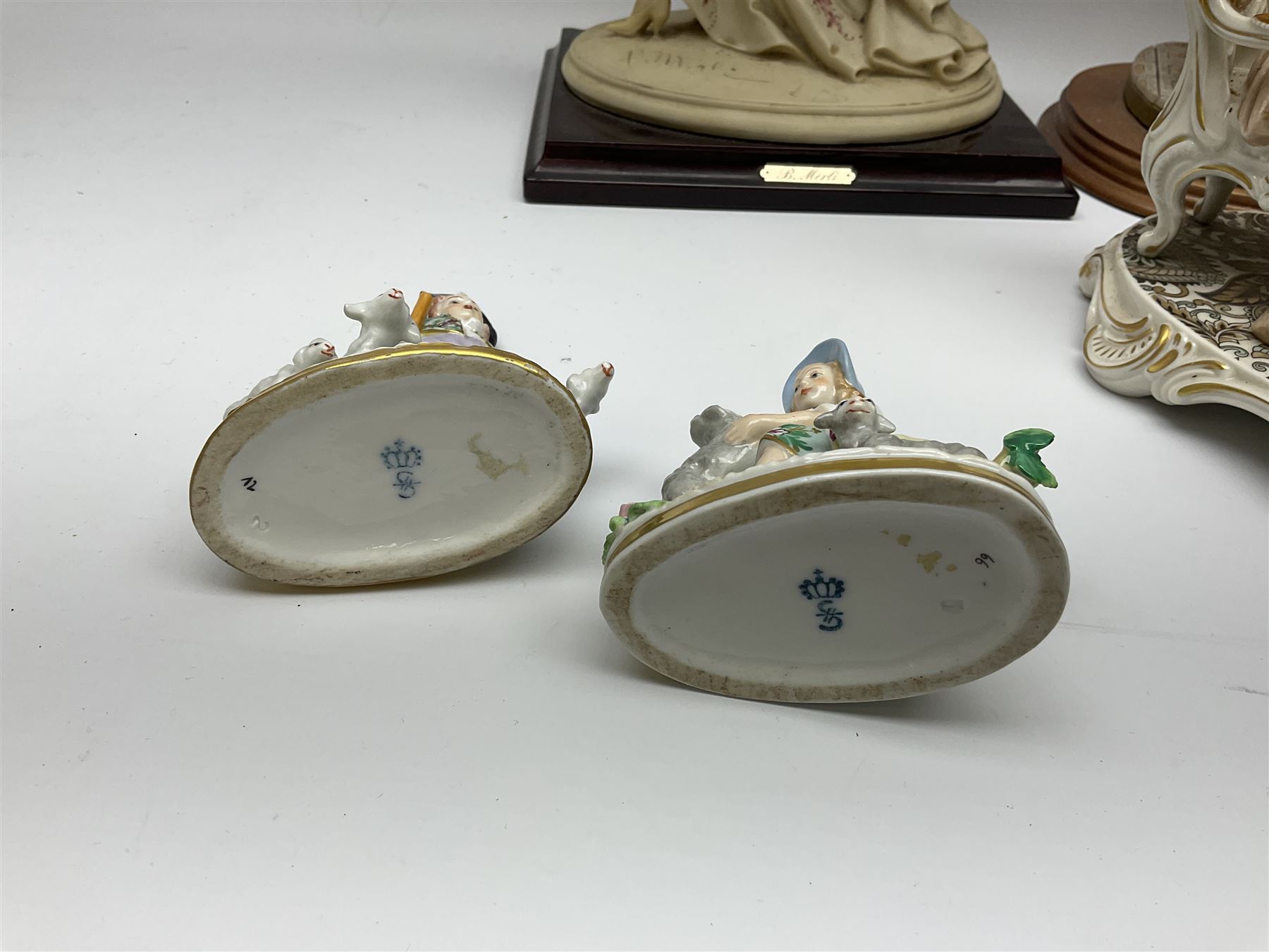 A small pair of Sitzendorf figures modelled as shepherd and shepherdess, H10.5cm together with a Dresden porcelain figure modelled as a female figure playing the piano, H17cm, a Naples figure with floral bouquet, H27.5cm,  a Naples figure holding a dog, H33cm, and a Leonardo Collection figure, Interlude, H24cm. 