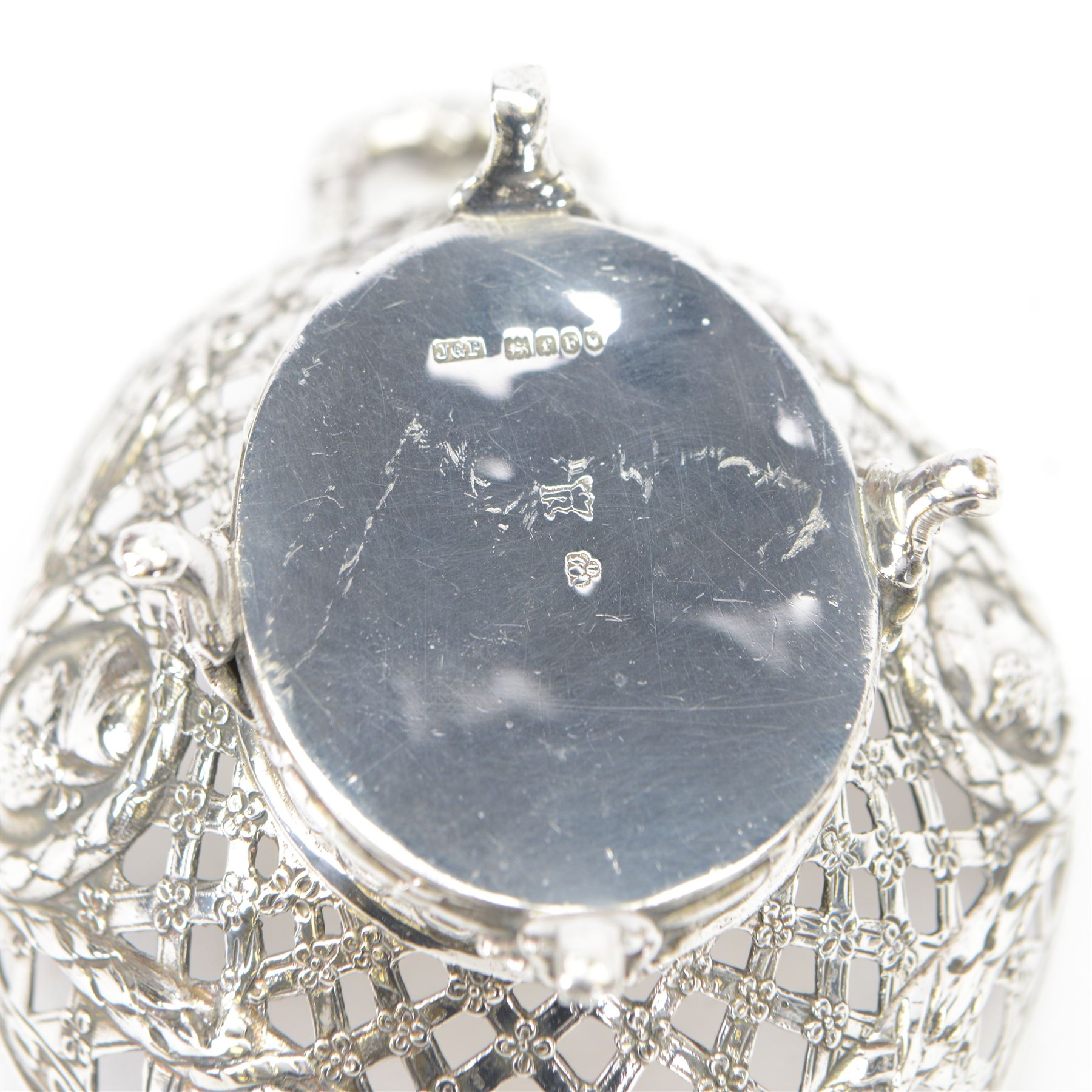 Late 19th/early 20th century German Hanau silver basket, modelled in George II style, of shaped openwork lattice form with twin handles, the body decorated with two portrait roundels and husk and ribbon swags, upon four scroll feet, with unattributed pseudo Hanau marks, and hallmarked John George Piddington, London import 1901, including handles H7cm W15cm
