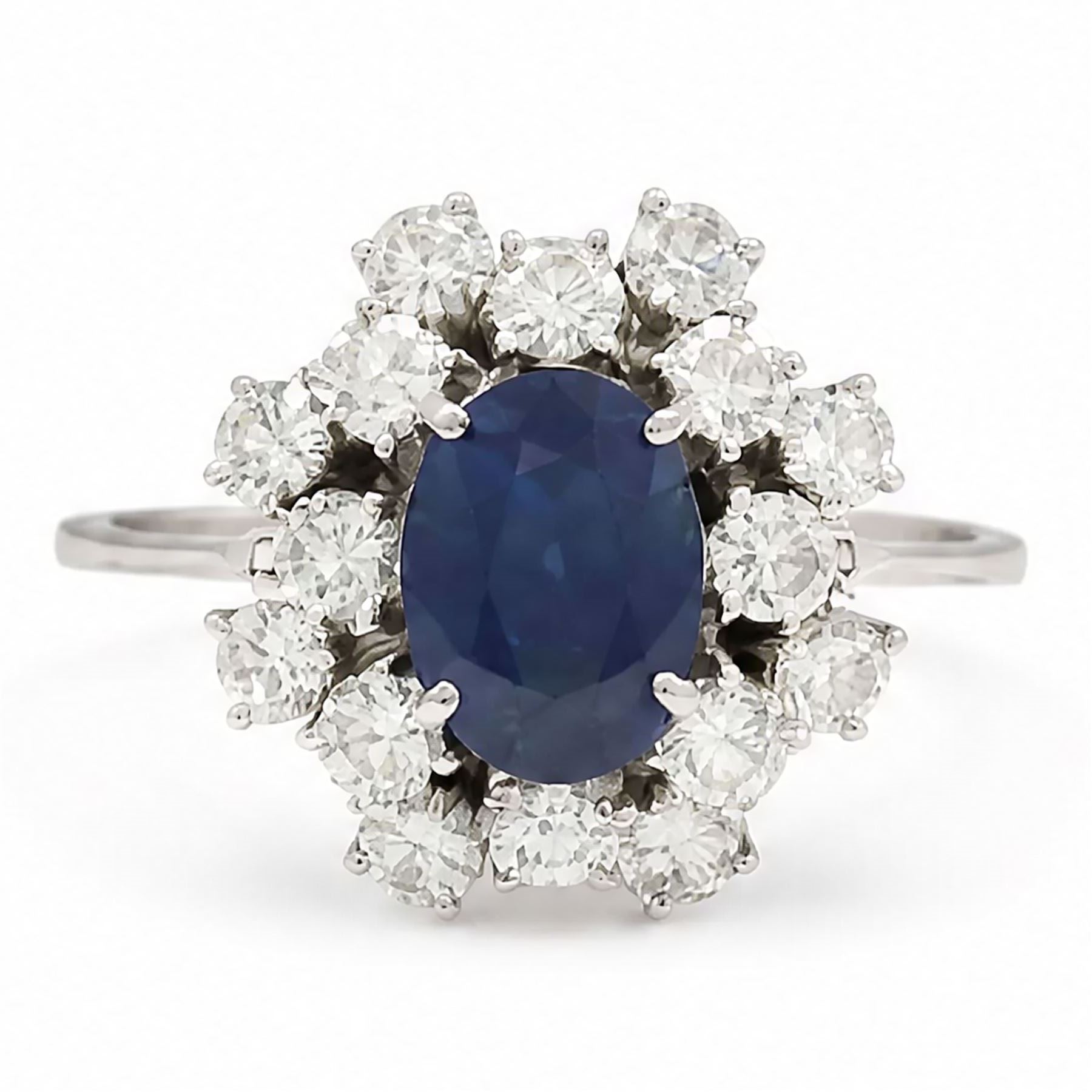 18ct white gold sapphire and diamond cluster ring, single oval cut sapphire of approx 2.10 carat, surrounded by sixteen round brilliant cut diamonds, total diamond weight approx 0.95 carat