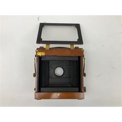 Ensign 'The Sanderson' folding plate camera in mahogany and lacquered brass, field model with canvas wrapped box, two mahogany photographic plates, 'Busch rapid Symmetrical F:8' lens,  and a wooden tripod 