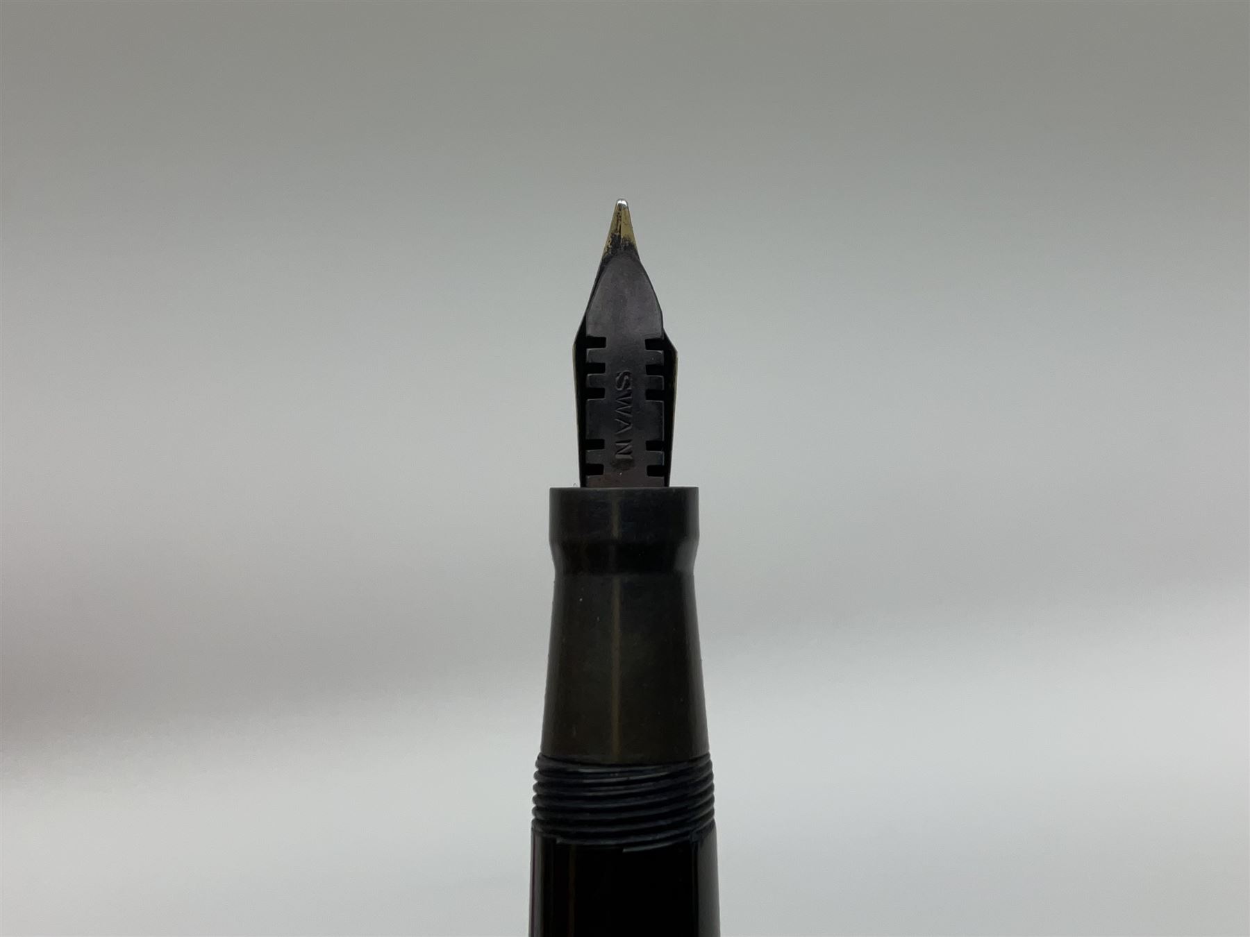 Vintage Swan Mabie Todd lever fill fountain pen in coral red, the nib a/f marked 14K, together with two further vintage Swan Mabie Todd fountain pens, the first example with lever fill, the other leverless, each with black body, one with nib marked 14ct, (3) 