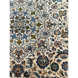 Persian Kashan ivory ground carpet, the interlaced foliate medallion surrounded by trailing plant motifs interlaced with scrolls, the guarded border with repeating stylised flower heads