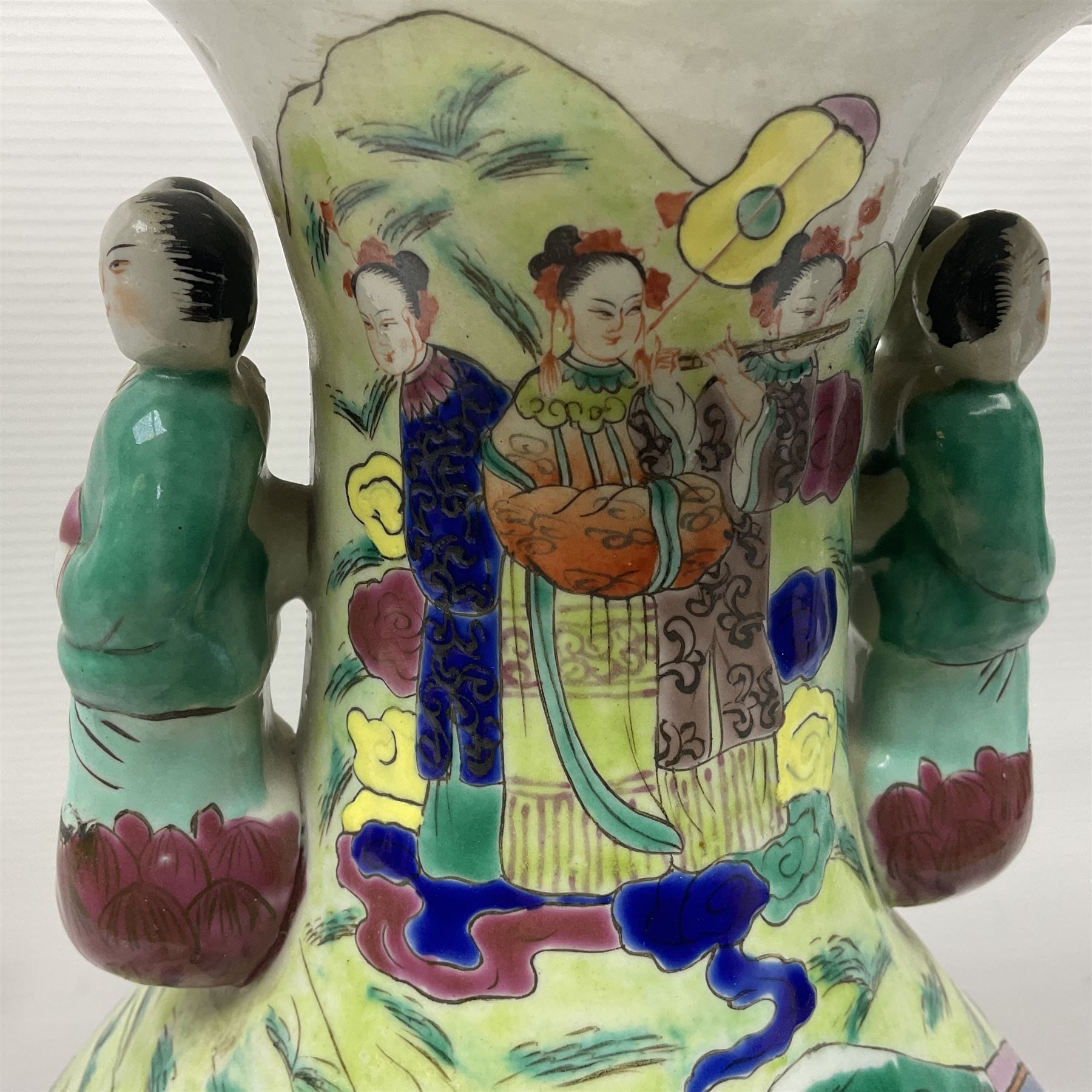 20th century Chinese Famille Rose vase, of baluster form with flared lobed rim and twin figural handles, decorated in polychrome enamel with figures dancing and playing instruments within a garden setting, H42cm