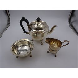 1920s three piece silver tea service, comprising teapot, with ebonised wooden handle and finial, milk jug and open sucrier, all of circular form, with shaped rims, and upon three hoof feet, hallmarked Wakely & Wheeler, London 1922, teapot H19cm