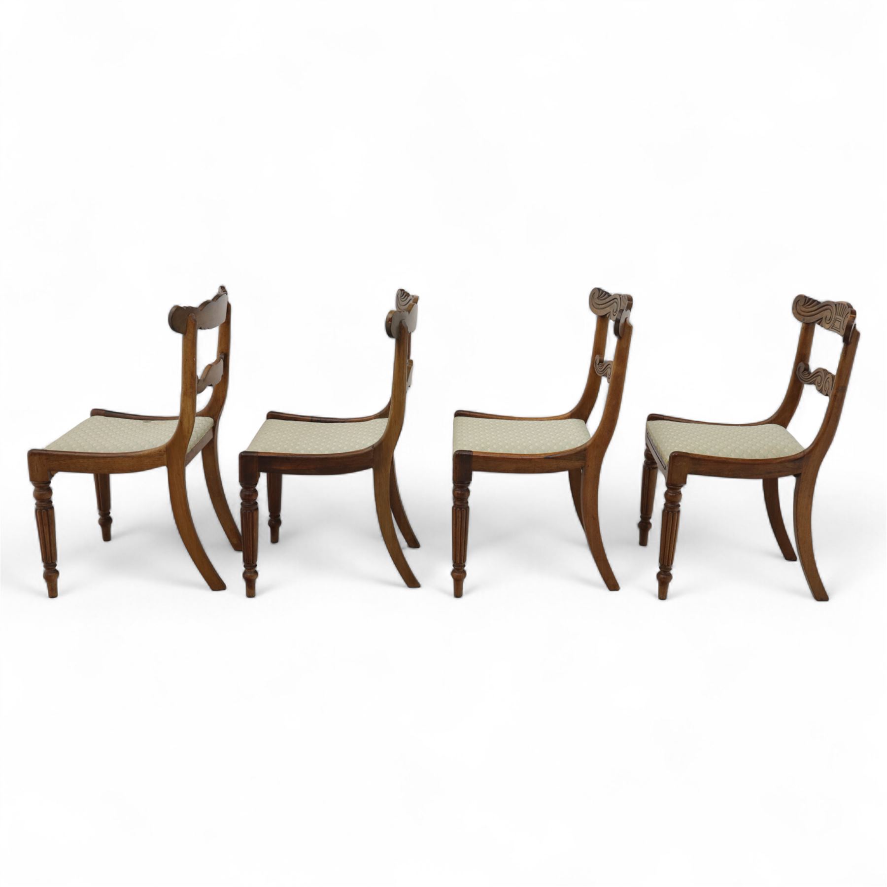 Set of four 19th-century rosewood dining chairs in the William IV style, shaped and carved top rail with fan and scroll decoration above a upholstered padded seat on reeded and turned front legs 