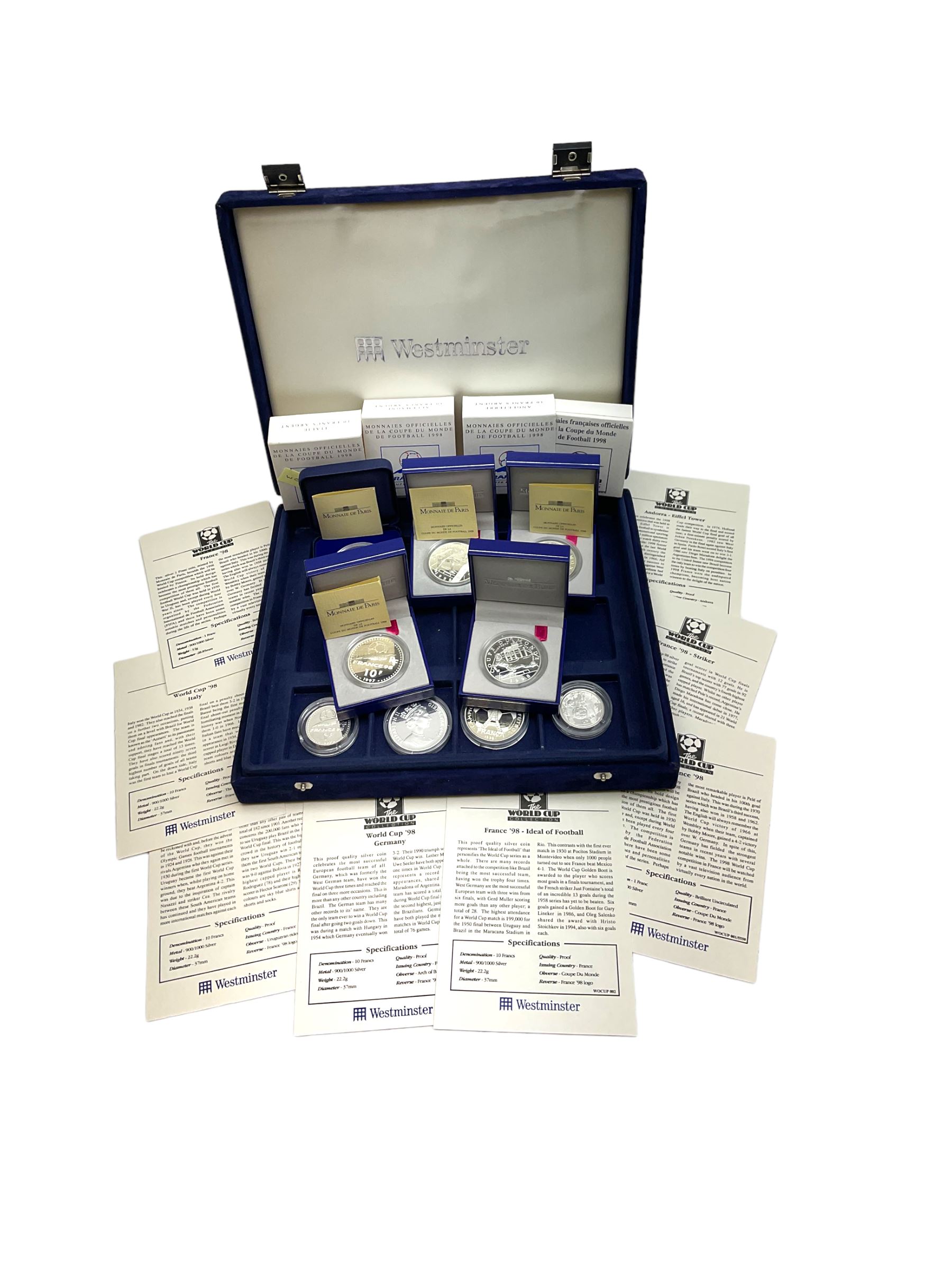 Nine commemorative coins relating to the France 1998 World Cup, some cased with certificates, in a blue coin storage box