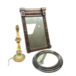 A Victorian oval ebonized mirror, H35cm, together with an early 20th century mahogany wall mirror with column detail, H53.5cm, and a papier-mâché table lamp. (3).  