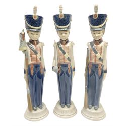 Three Lladro soldier figures, comprising Cadet Captain no 5404, Flag Bearer no 5405 and At Attention no 5407, all with original boxes, H30.5cm  