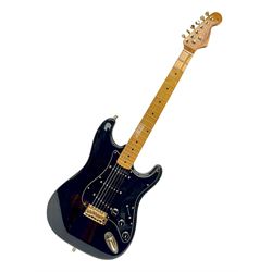 Copy of a Fender Stratocaster electric guitar in black with Wilkinson bridge, lock-in tuners, synchronised tremolo and various patent numbers; L99cm; in hard carrying case with strap and digital tuner