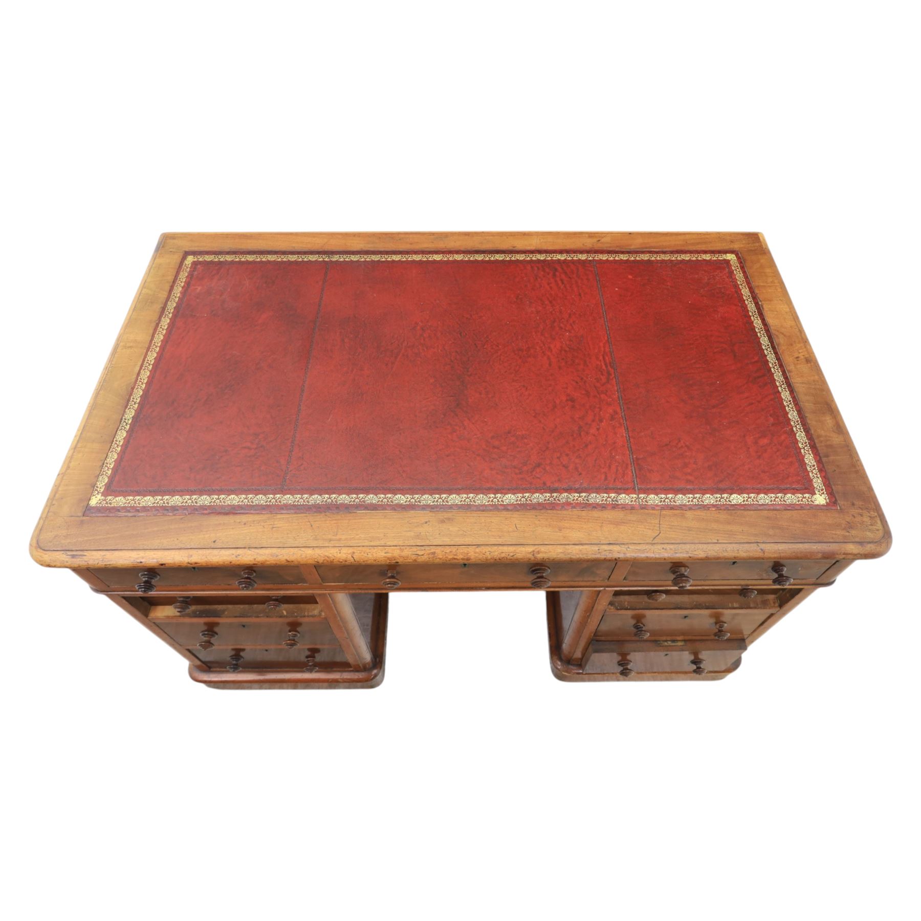 Victorian mahogany writing desk, featuring inset tooled red leather top, raised on two pedestals, nine drawers with figured veneer fronts