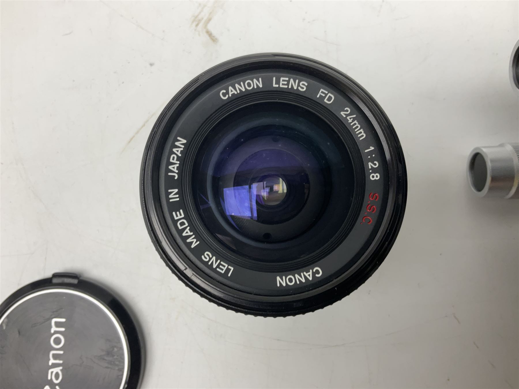 Collection of Canon lenses, to include 'Canon Lens FD 100mm 1:2.8', serial no 12821, 'Canon Lens FD 200mm 1:4' serial no 245313, 'Macro Canon Lens FL 50mm 1:3.5', serial no. 25505, 'Canon Lens FD 135mm 1:3.5 etc, together with other Canon equipment, including Bellows FL, Slide Duplicator etc 