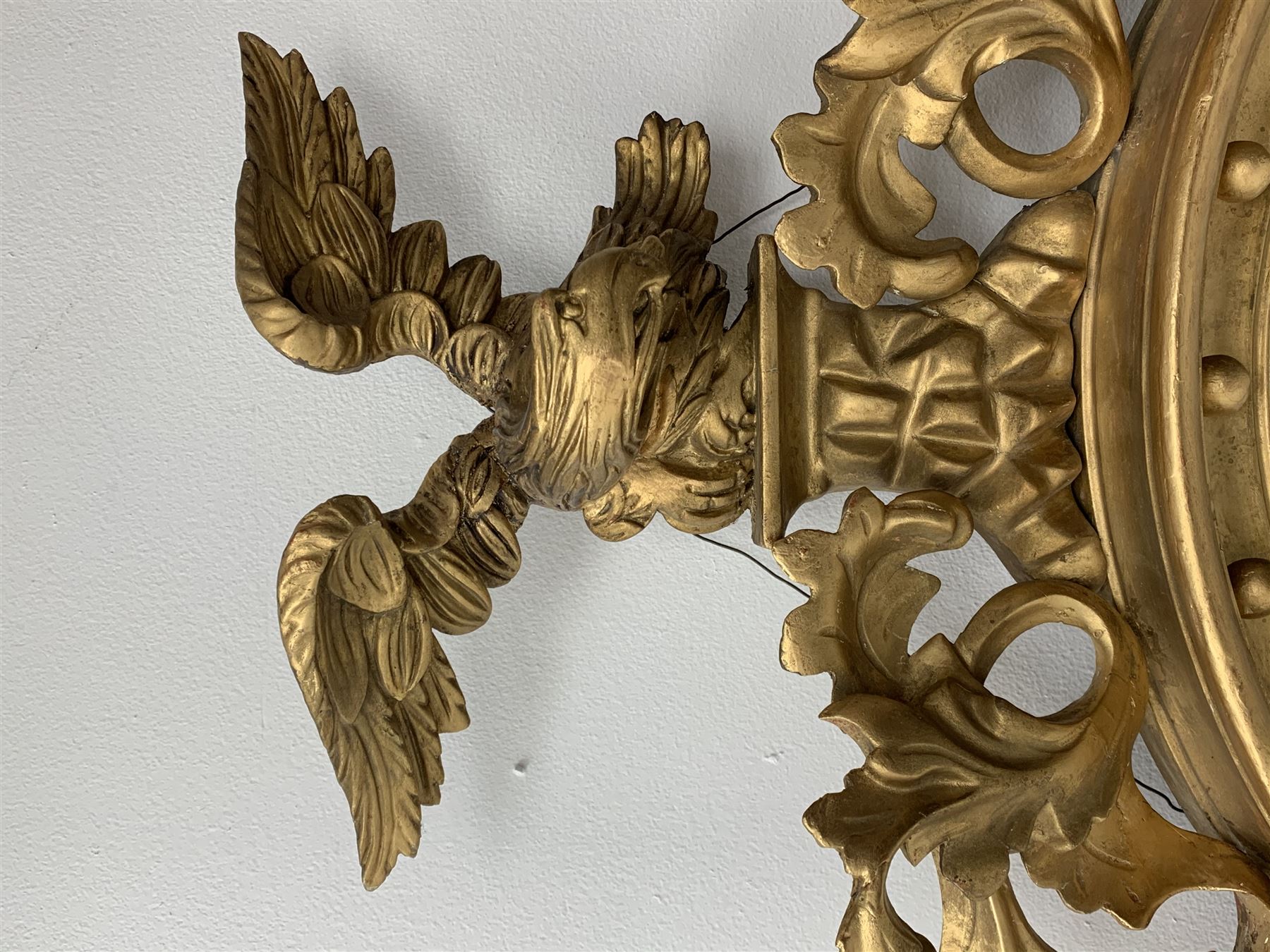 Large Regency carved wood and gesso circular convex mirror, eagle pediment on platform flanked by acanthus leaf scrolls, moulded surround and ebonised slip