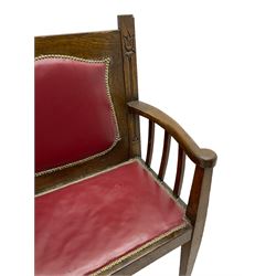 Early 20th century Arts & Crafts oak three-seat settle, upholstered in red leather with stud work, carved with Tulip flowers and scrolled foliage, on square tapering supports with spade feet