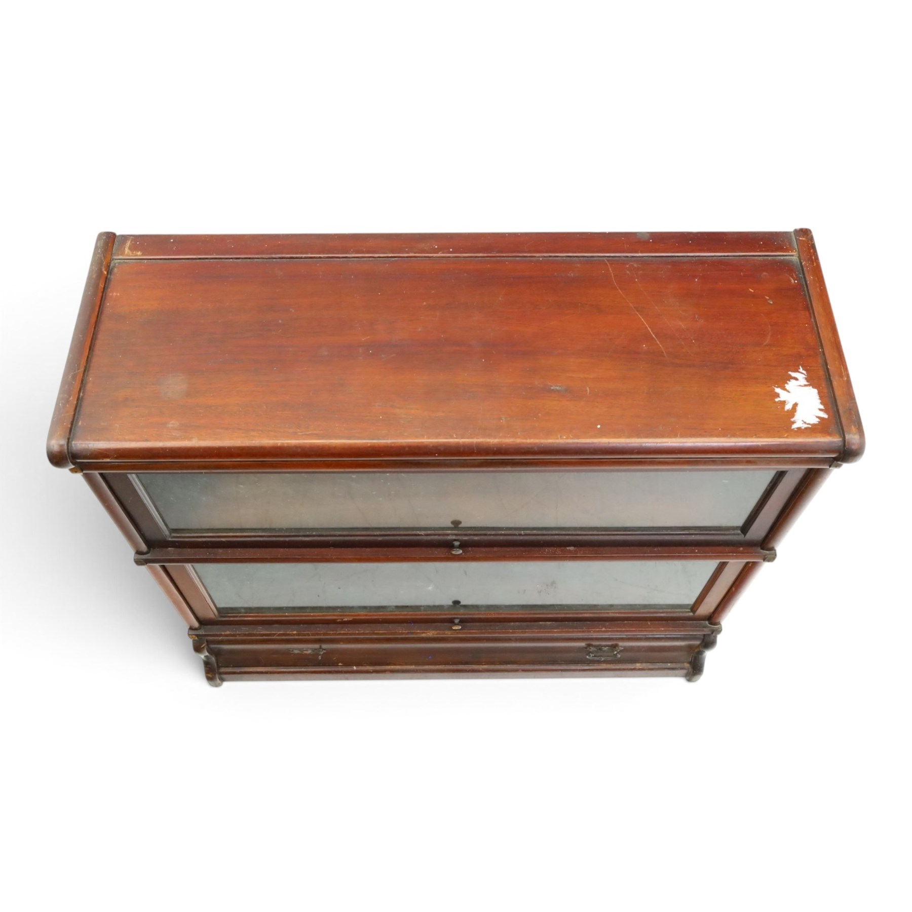 Globe Wernicke - early 20th century mahogany two-tier stacking library bookcase, fitted with glazed up-and-over doors, two drawers to the plinth base; together with a similar single-tier example (W87cm D27cm H54cm)