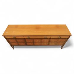 Nathan - mid 20th century teak sideboard, fitted with three drawers with brass ring handles, above a central fall front cabinet, flanked by two cupboard doors, raised on square tapering supports