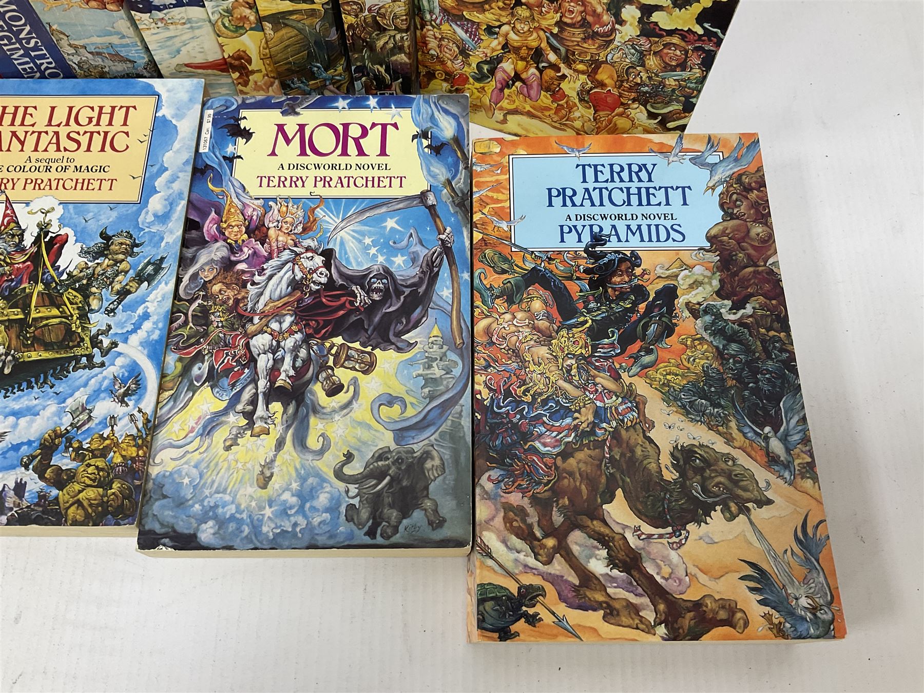 Collection of books by Terry Pratchett, of mostly Discworld interest, to include hardback edition of Going Postal, and further books such as Men at Arms, Sourcery, Small Gods etc 