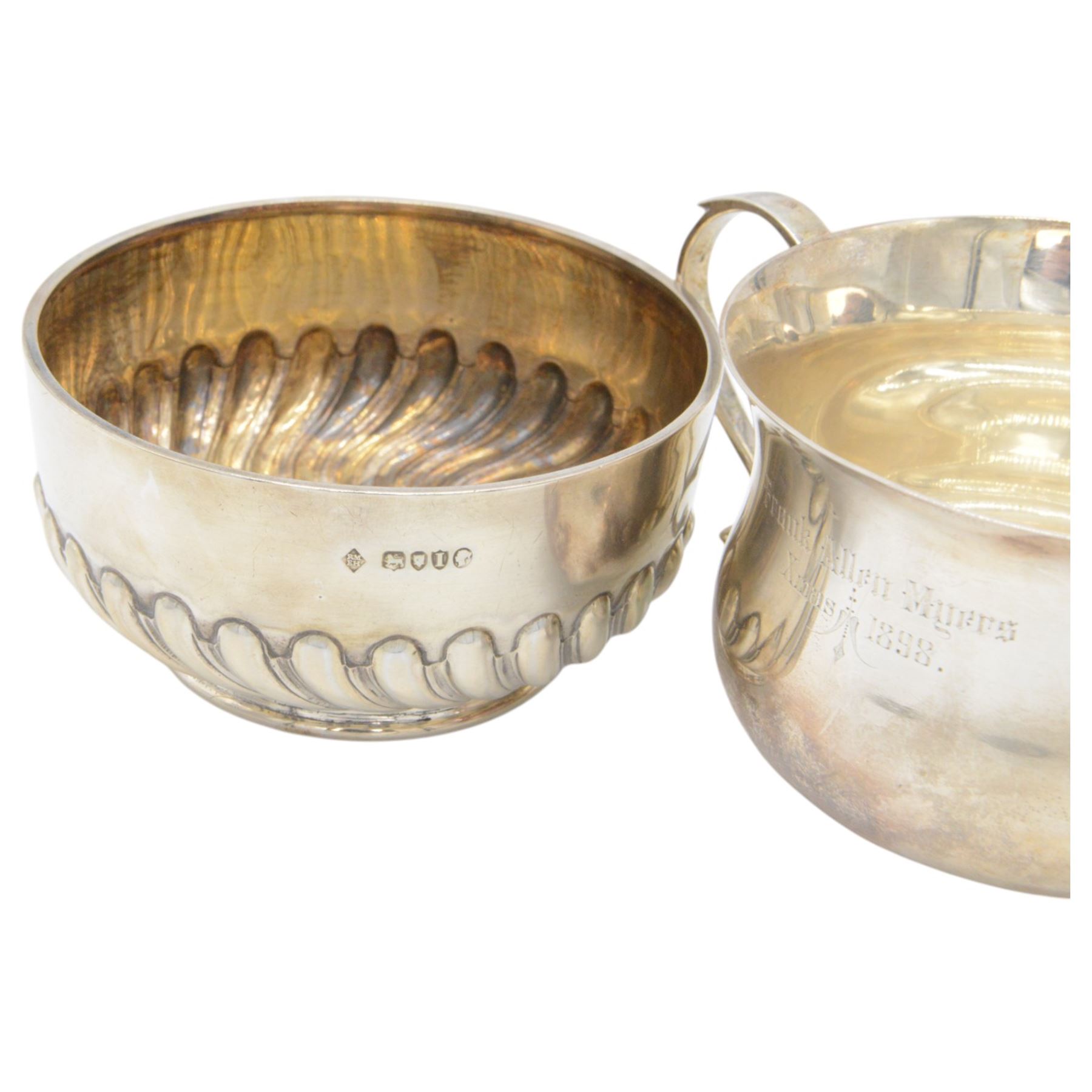 Two Victorian silver Christening sets, the first a twin handled porringer with presentation engraving to body and a matching spoon with rattail bowl, hallmarked Wakely & Wheeler, London 1898, the second example with circular part fluted bowl and matching spoon with twist handle and palmette finial, hallmarked Martin, Hall & Co, London 1884, both contained within tooled leather cases with fitted blue velvet and silk interior