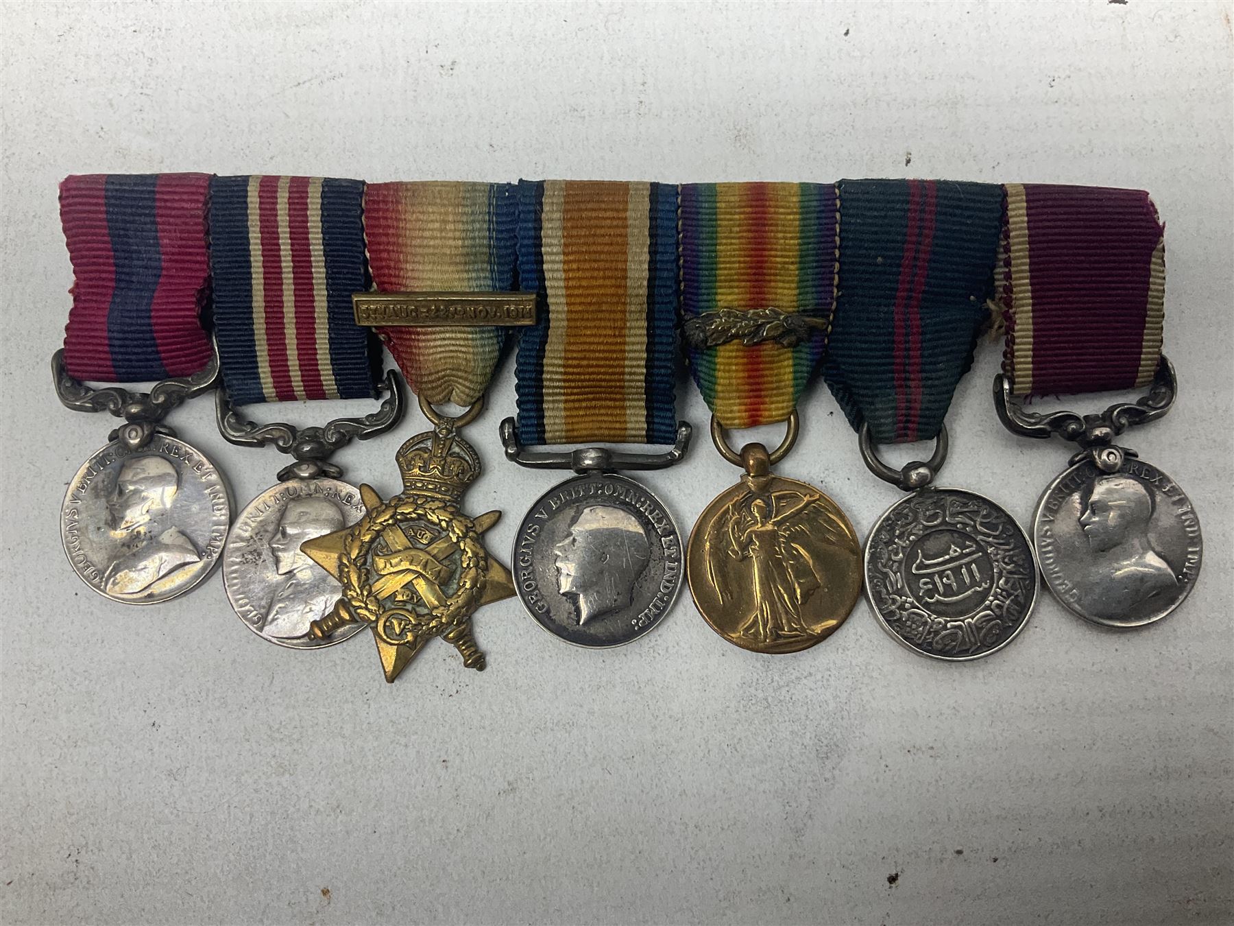 George V Military Medal and Distinguished Conduct Medal miniature group of seven medals comprising MM, DCM, WW1 trio including 1914 Star with date clasp and MID leaves, The Great Durbar Delhi 1911 Medal and LSGC; on pinned wearing bar; WW1 Military Medal miniature group of three comprising MM, BWM and Victory; Victoria North West Canada 1885 miniature; and George VI miniature Territorial Efficiency medal; all with ribbons