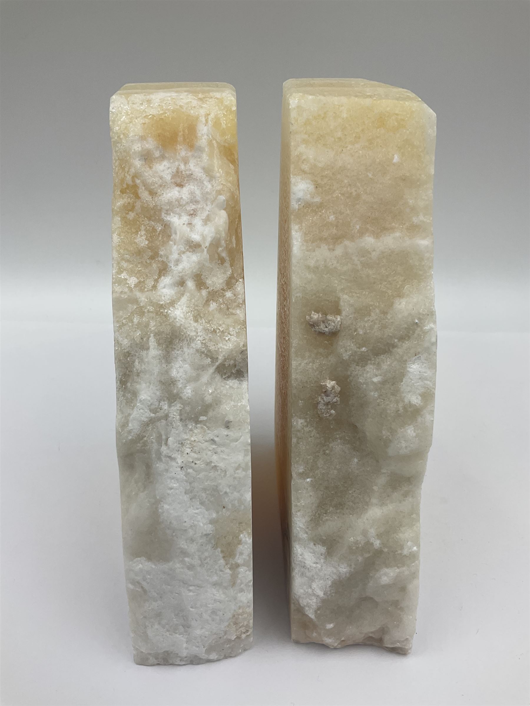 Pair of honey onyx bookends of rectangular form with polished to three sides with a raw outer edge, H18cm 