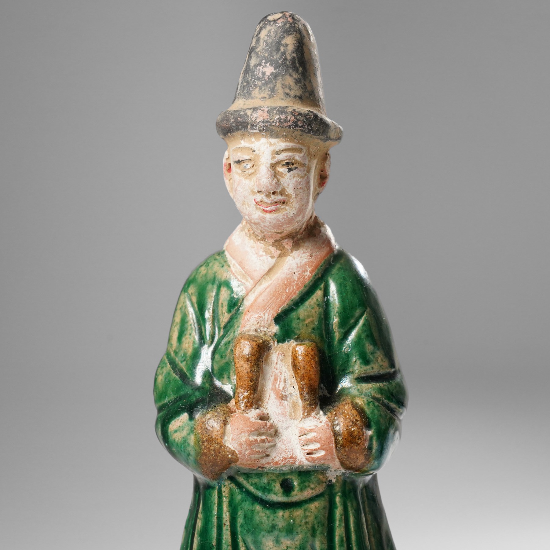 Pair of Chinese terracotta court attendant tomb figures,  probably Ming Dynasty, in Sancai green glaze, upon stepped square bases, H22cm 